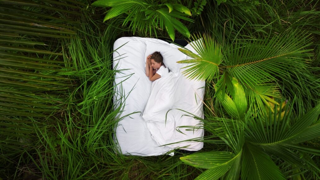 A hidden place. Sleeping woman in deep jungle forest lies on airbed,View from above